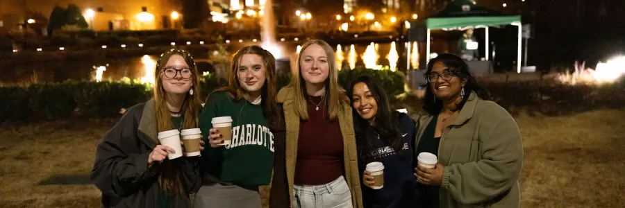Five students drinking hot cocoa at the Light Up the Lake evening event