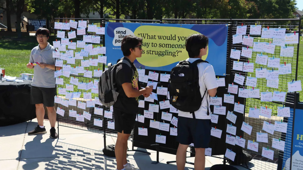 Students next to a board about what to say to someone who is struggling